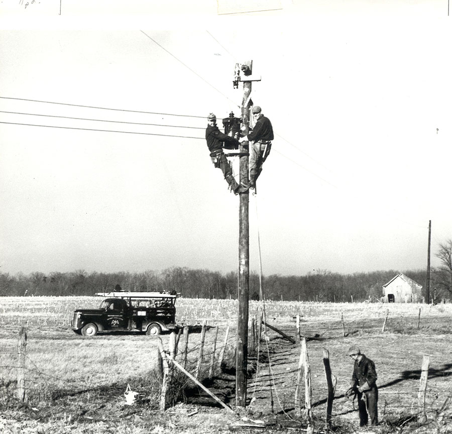 Old photo of linemen on top of a utility pole