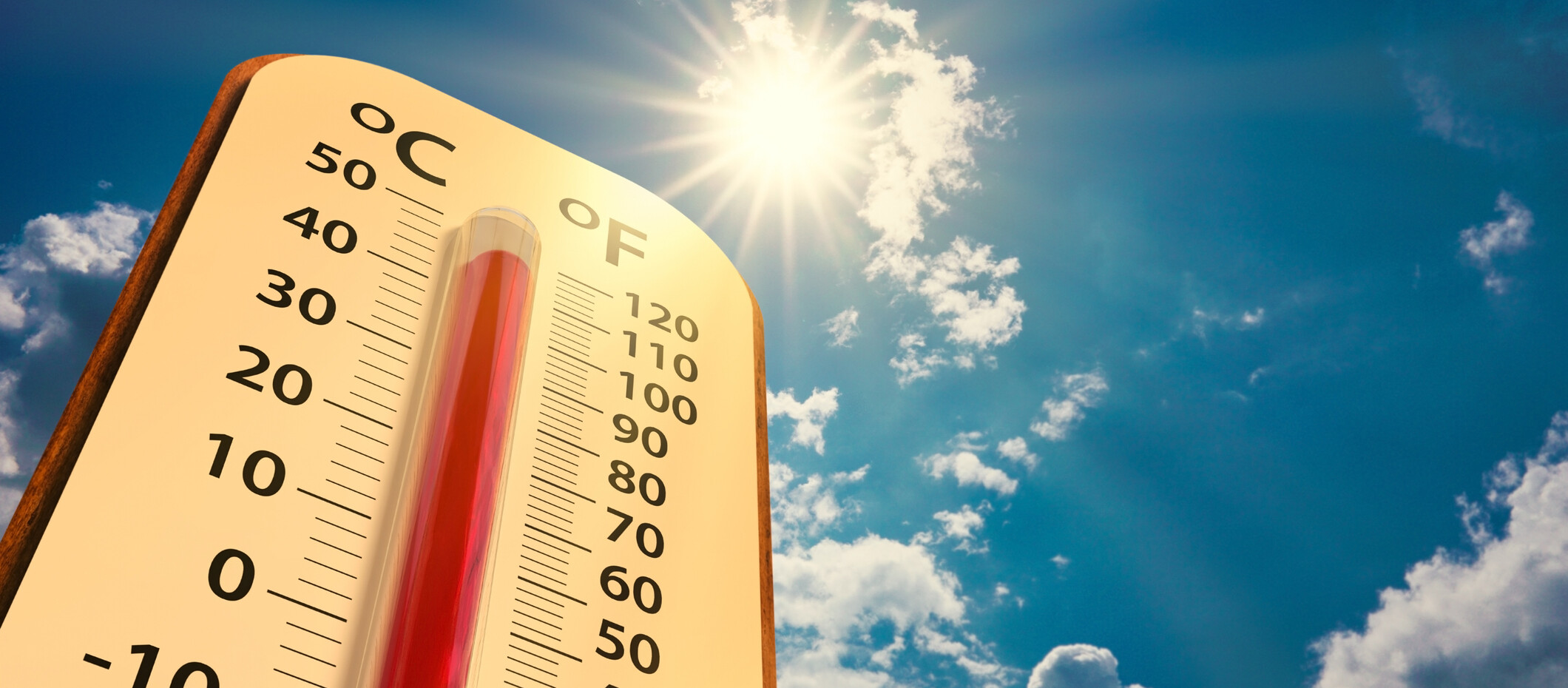 low angle view Thermometer on blue sky with sun shining